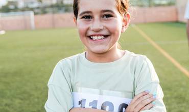 Carreras solidarias en centros educativos Una niña con el dorsal de una carrera