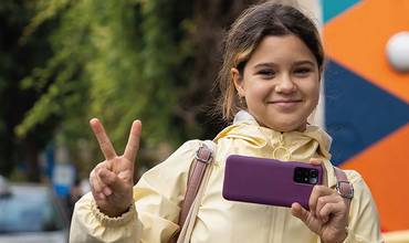 Una niña posa con su móvil mientras hace una foto. Portada del Informe sobre el impacto de la tecnología en la infancia y la adolescencia de UNICEF España