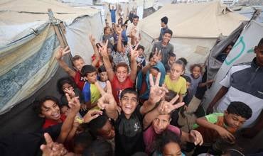 Niños celebran el anuncio de alto el fuego en Gaza.