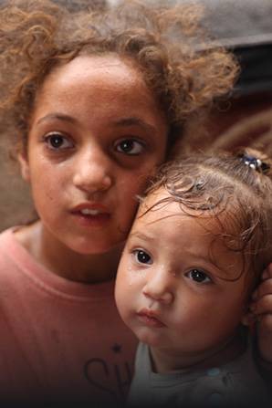Rama, de 11 años, con su hermana Malak, de 1, en la Franja de Gaza. Rama de 11 años con su hermana de 1.