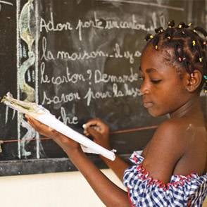 Educación Una niña con un cuaderno de frente de una pizarra